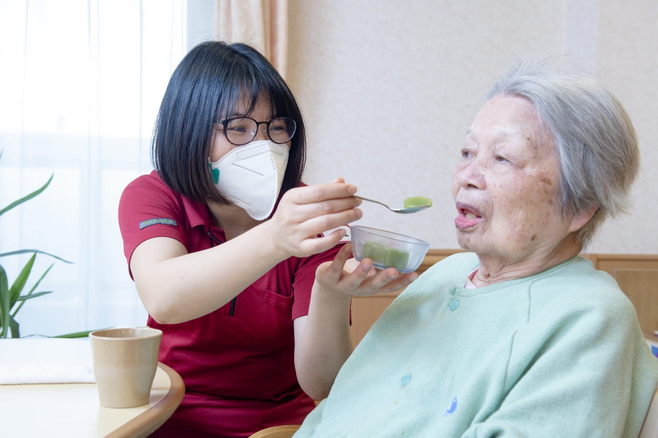 食事を介助する職員と利用者様